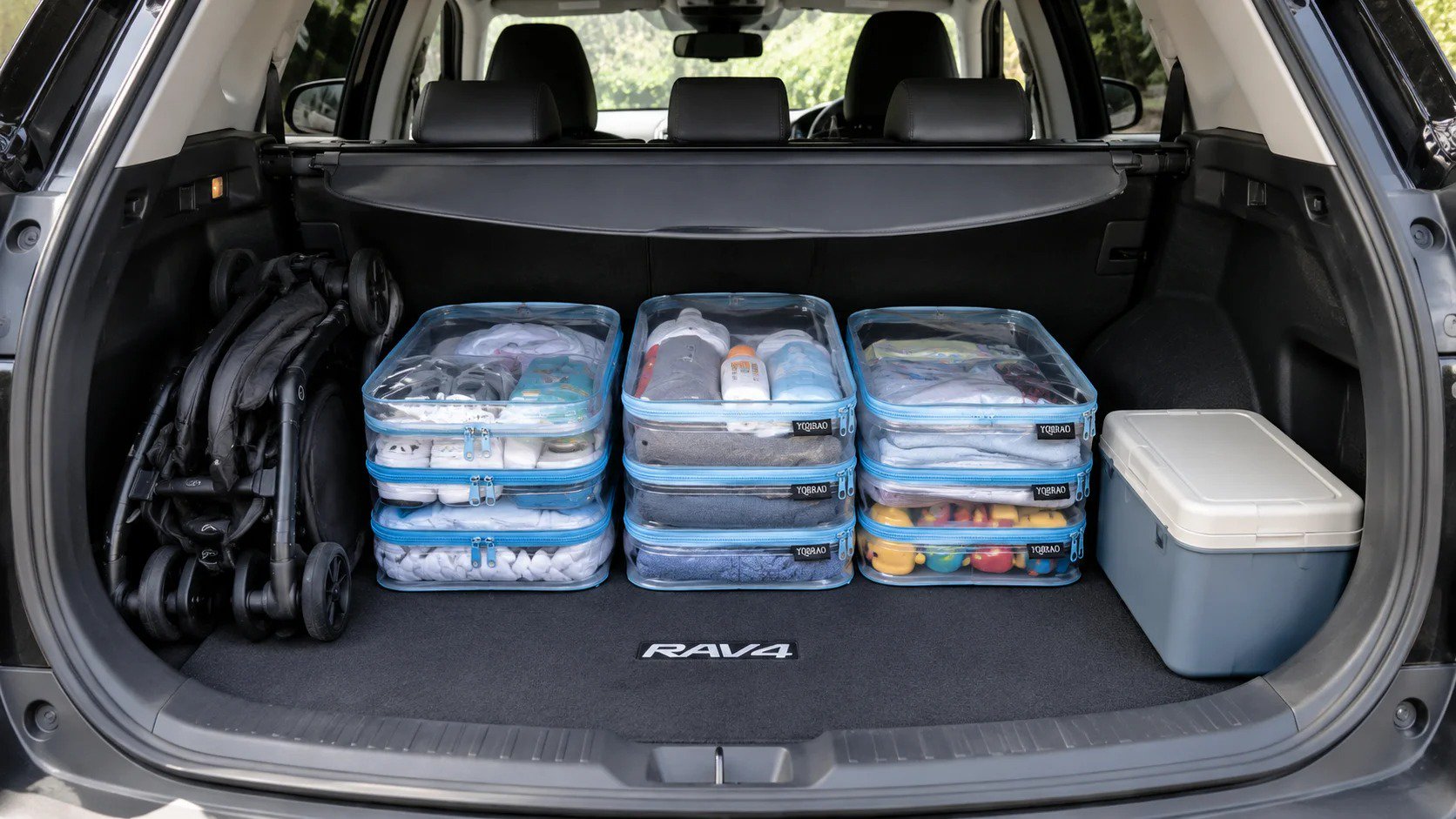 Toyota RAV4 open trunk with three clear hard-shell organizer pouches arranged modularly around wheel-well intrusions, leaving space for a stroller and cooler on either side.